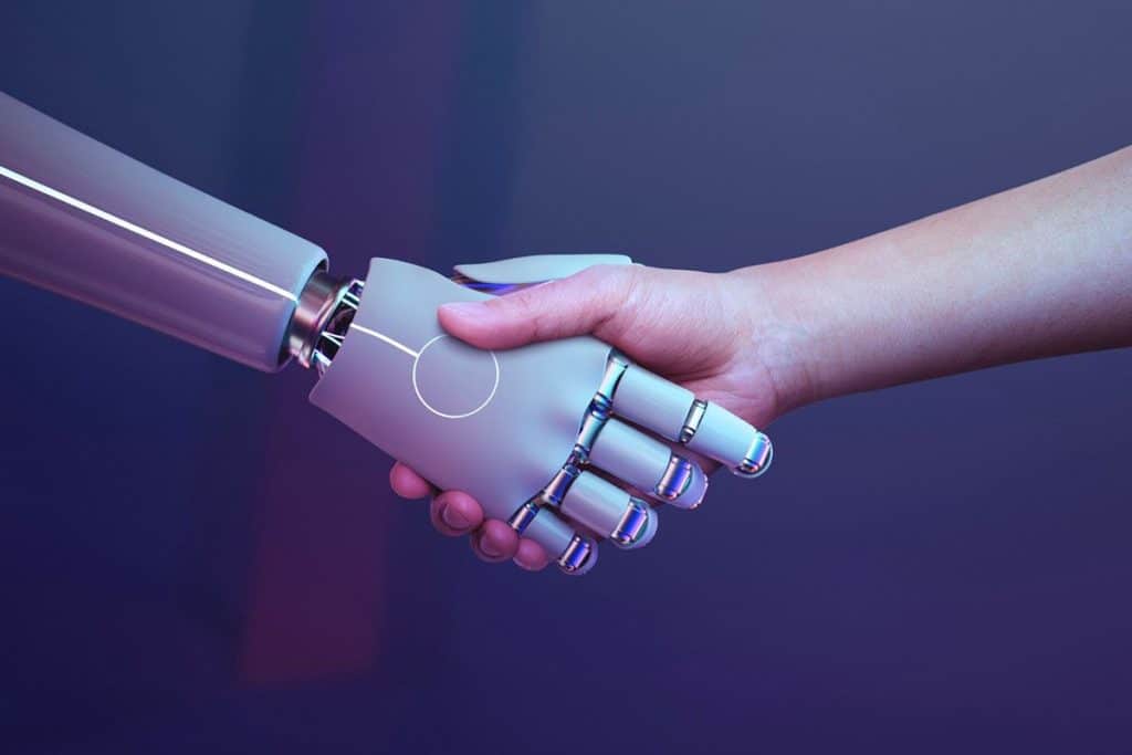 Une main de robot qui sert une main humaine sur fond bleu