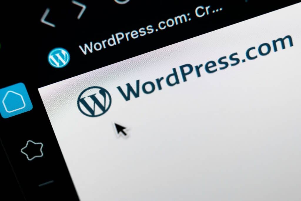 Un écran avec le logo de WordPress, une souris pointant sur l'adresse WordPress.com.
