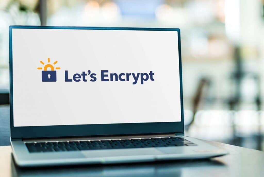 Un ordinateur portable posé allumé sur une table. L'écran est allumé sur le logo de Let's Encrypt, fournisseur de certificats ssl