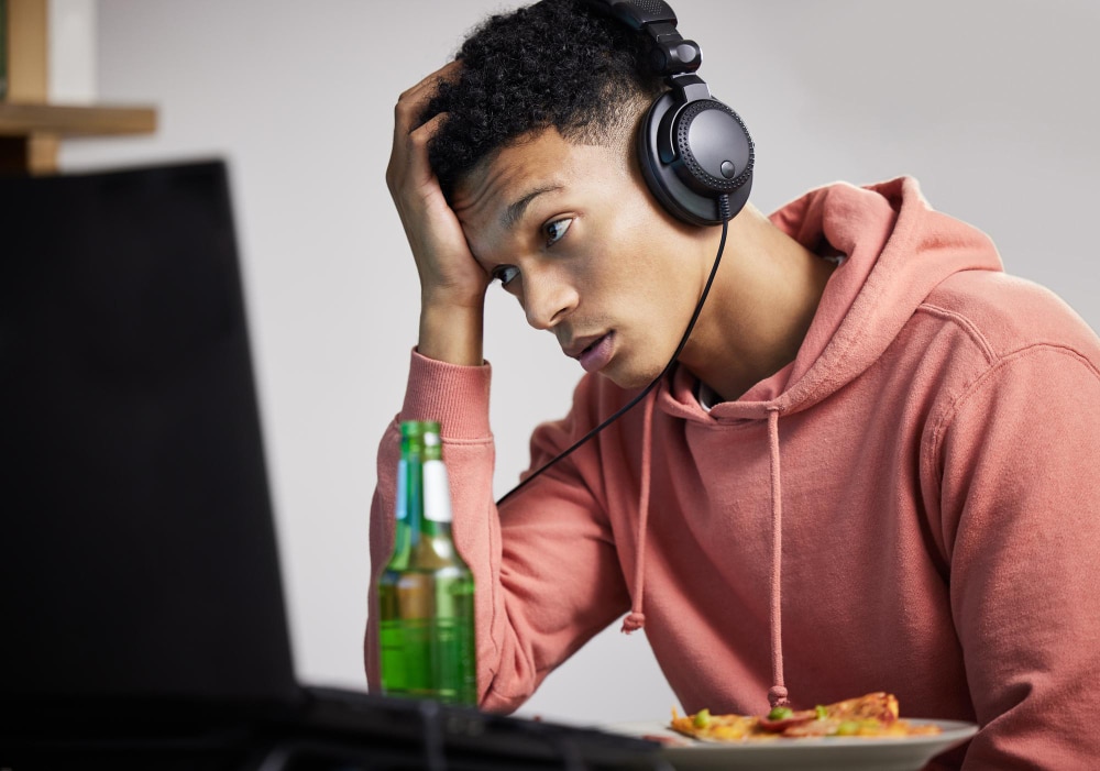 Un jeune homme qui patiente devant son ordinateur parce que le serveur ralentit la vitesse du site wordpress