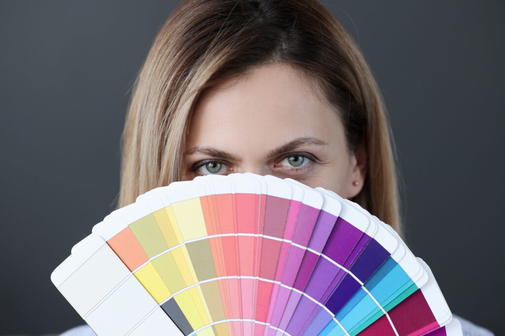 Une jeune femme tenant un éventail de palette de couleur.