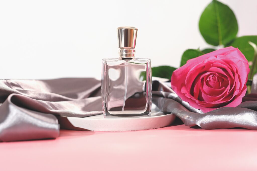 flacon de parfum sans marque à côté d'un rose rouge à revendre sur Aliexpress