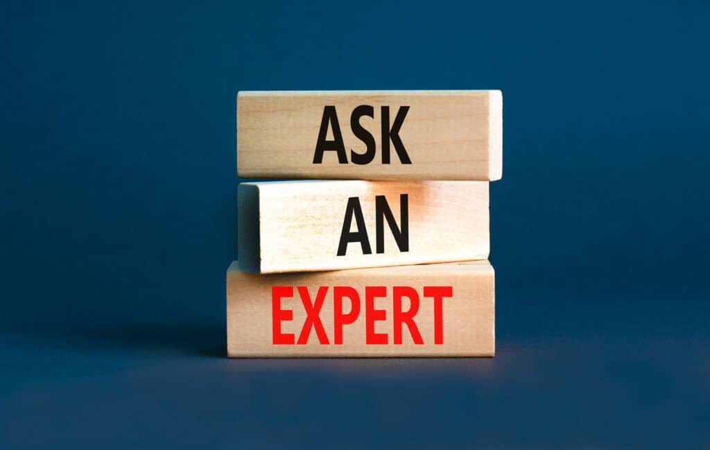 3 blocs de bois empilés avec écris "demandez un expert" dessus