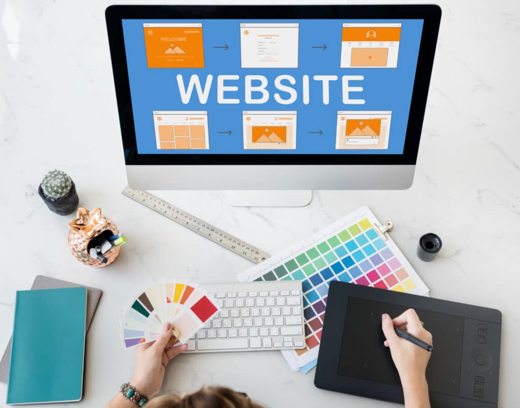 Une main tenant une palette de couleur devant un écran avec des templates de site web.