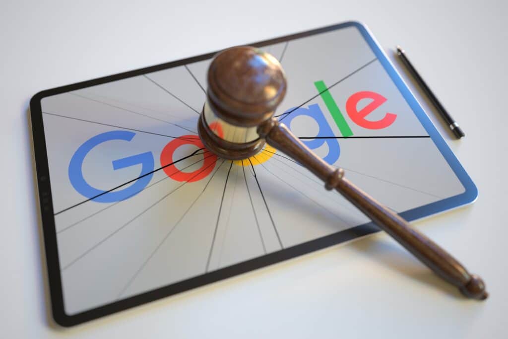 Une tablette allumée sur le logo de Google avec un maillet de juge, pour représenter les pénalités de SEO black hat